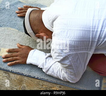 Homme musulman priant avec tapis sur le sol avec photo de stock de personnes Banque D'Images