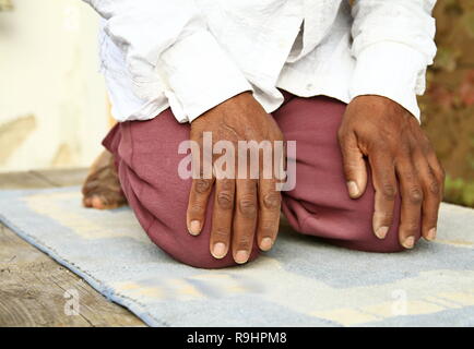 Homme musulman priant avec tapis sur le sol avec photo de stock de personnes Banque D'Images