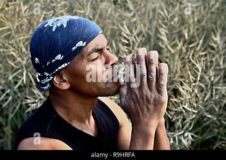 Homme priant à dieu avec les mains ensemble Caraïbes homme priant photo Banque D'Images