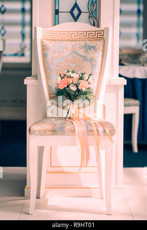 Des fleurs de mariage, bouquet de mariée sur chaise dans interere lumineux. 2019, concept tendance couleurs corail vivant Banque D'Images