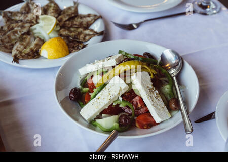 Petite friture de poissons au citron et salade grecque Banque D'Images