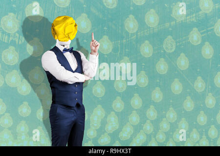 Un homme en costume avec une ampoule jaune froissé de papier au lieu d'une tête avec un doigt, le concept de l'idée, sur le fond de lumière Banque D'Images