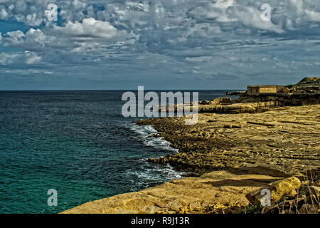 La Côte d'Xaghjra à Malte au cours de l'hiver. Une marine de Malte avec le rivage, mer calme et nuages dans une journée d'hiver. Banque D'Images