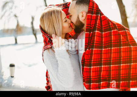 Jolie blonde wallking élégante dans un parc d'hiver avec son petit ami Banque D'Images