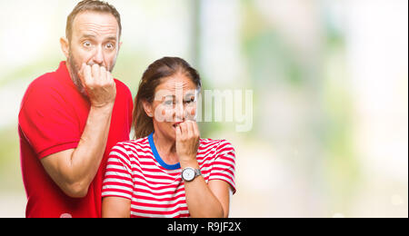 L'âge moyen hispanic couple dans l'amour sur fond isolé à souligné et nerveux avec les mains sur la bouche de mordre les ongles. Problème d'anxiété. Banque D'Images