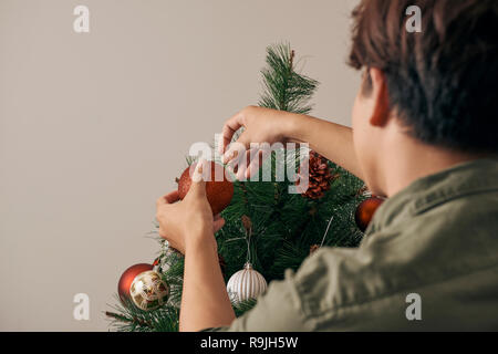 Bel homme avec christmas baubles and looking at camera à l'hom Banque D'Images