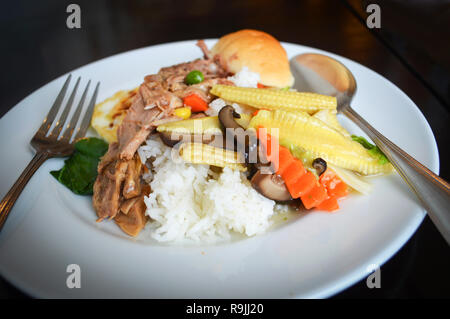 Petit-déjeuner sauté de champignons légumes carotte maïs mixtes et côtelettes de porc sur riz plaque blanche Banque D'Images