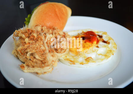 Le petit-déjeuner pain frit oeufs Vegetable Burger et séché de porc déchiqueté sur le riz plaque blanche Banque D'Images