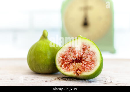 Balance de cuisine rétro / antique et figues mûres, coupées en deux sur la table en bois naturel Banque D'Images