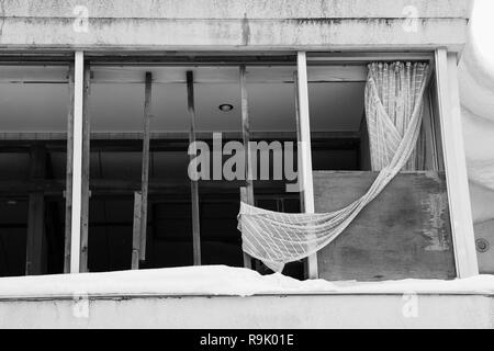 Vue à travers une fenêtre cassée d'un hôtel abandonné à Hokkaido, au Japon. Banque D'Images