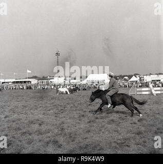 1967, Thame Show, Oxfordshire, une dame à cheval un petit cheval bareback, sans selle ou faisceau, la tenue à la crinière du cheval, England, UK. Le show est le plus grand salon de l'agriculture d'une journée en Grande-Bretagne et le bien que la première manifestation officielle a eu lieu en 1888, c'est l'origine remonte à 1855 lorsqu'un concours de labour il y a eu lieu. Banque D'Images