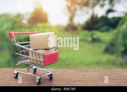 Shopping concept : Cartons ou boîtes de papier dans votre panier sur table en bois brun. magasinage en ligne les consommateurs peuvent acheter de maison et le service de livraison. wit Banque D'Images