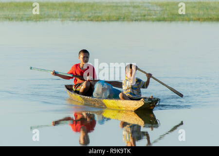 NAKHON PHANOM, THAÏLANDE - OCT 16, 2018 : Deux enfants paddle bateau en bois sur le lac Banque D'Images