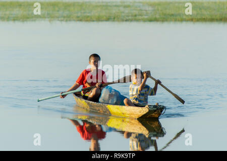 NAKHON PHANOM, THAÏLANDE - OCT 16, 2018 : Deux enfants paddle bateau en bois sur le lac Banque D'Images