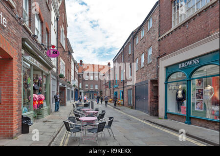 Les bâtiments en briques anciennes immobilier boutiques et restaurants sur allée de Back Swinegate dans quartier historique de la ville de York, England, UK Banque D'Images