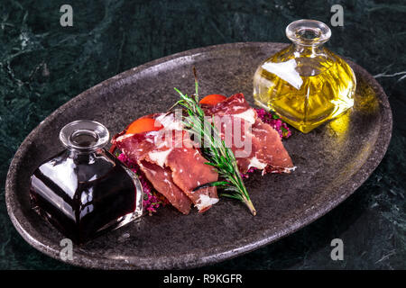 La sauce soja et l'huile d'olive avec des tranches de bacon turcs sur fond de marbre Banque D'Images