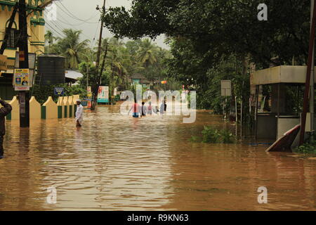 Personnes pataugeant dans l'eau durant les inondations 2018 Kerala le long d'une route submergée. De fortes inondations en Inde du Sud. Banque D'Images