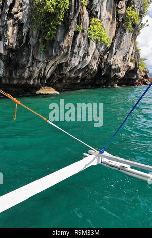 De l'eau vert-outrigger truquage des Philippines de bangka bateau d'Pinasil face à la Cathédrale de l'île de l'intérieur des grottes allumé quelques fois par jour de soleil par Banque D'Images