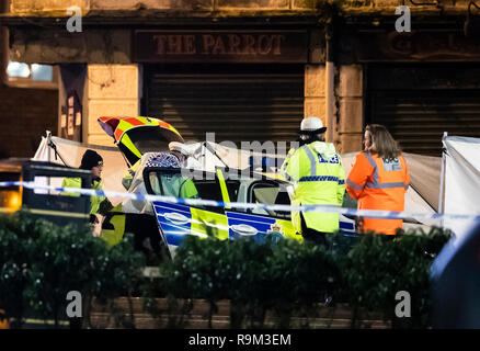 Un écran entoure un véhicule de police avec un pare-brise fracassé lors d'un accident sur la route près de l'Ecosse Wallasey tunnel à Liverpool où un homme est mort après avoir été frappé par une voiture de police dans la nuit de Noël. Banque D'Images