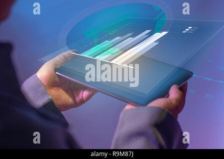 Businessman à la graphique et le rapport de synthèse sur l'écran de tablette numérique avec l'analyse de données résultat, isolé sur fond bleu. Les gens modernes faisant busi Banque D'Images