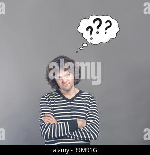 L'homme sceptique et méfiant à demander avec appelée nuage de pensées avec trois points d'interrogation. Désapprobation face à certains sur gris backg Banque D'Images