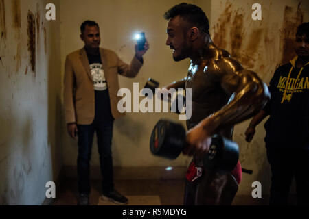 Dhaka, Bangladesh. 25 Dec 2018. Body builder l'échauffement lui-même avant d'entrer dans la compétition de bâtiment de corps. Les culturistes et se préparer pour l'athlétisme local M. Bangladesh la concurrence. Credit : SOPA/Alamy Images Limited Live News Banque D'Images