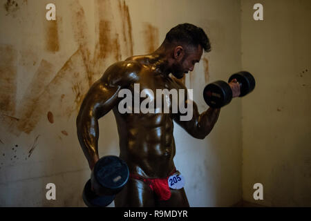 Dhaka, Bangladesh. 25 Dec 2018. Body builder l'échauffement lui-même avant d'entrer dans la compétition de bâtiment de corps. Les culturistes et se préparer pour l'athlétisme local M. Bangladesh la concurrence. Credit : SOPA/Alamy Images Limited Live News Banque D'Images