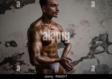 Dhaka, Bangladesh. 25 Dec 2018. Body builder pose pour une photo pour montrer ses muscles, avant de rentrer pour un concours de bâtiment de corps. Les culturistes et se préparer pour l'athlétisme local M. Bangladesh la concurrence. Credit : SOPA/Alamy Images Limited Live News Banque D'Images