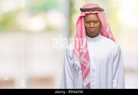 Jeune arabe african man wearing keffieh traditionnel isolé sur fond d'arrière-plan et l'inquiétude de la détresse, de pleurer en colère et peur. Triste expressi Banque D'Images