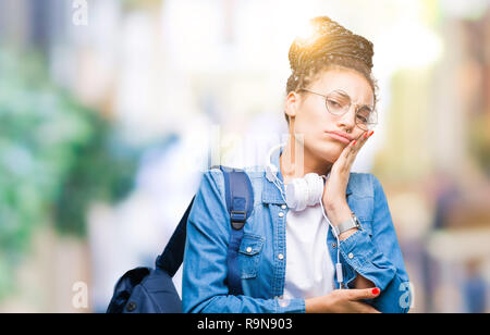 Les jeunes cheveux tressés african american student girl wearing backpack isolé sur la pensée d'arrière-plan l'air fatigué et ennuyé par la dépression Les problèmes w Banque D'Images