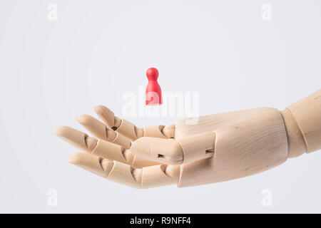Entreprise et design - main en bois avec échecs rouge isolé sur fond blanc Banque D'Images