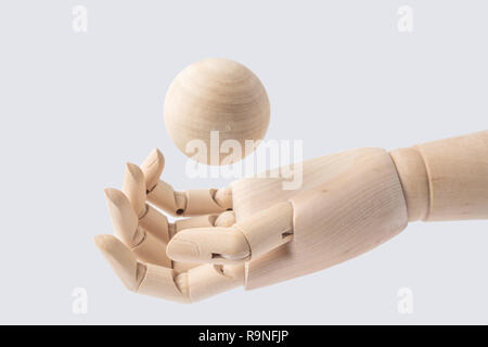 Entreprise et design - main en bois avec balle en bois isolé sur fond blanc Banque D'Images