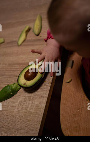 La main de l'enfant atteint de l'avocat. Une alimentation saine pour les enfants Banque D'Images