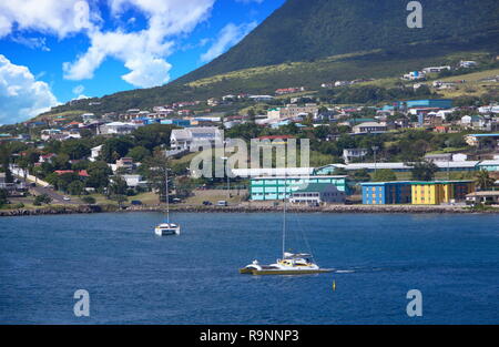 Voiliers amarrés au large de St Kitts près de Green Hills et maisons colorées Banque D'Images