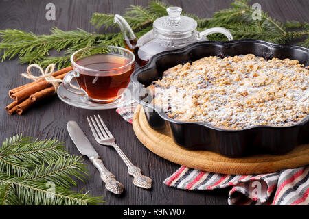 Gâteau de Noël au four avec de la cannelle, noix et fruits secs en pain sur table rustique de fête Banque D'Images