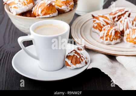 Bonbons savoureux et tasse de café sur fond de bois Banque D'Images