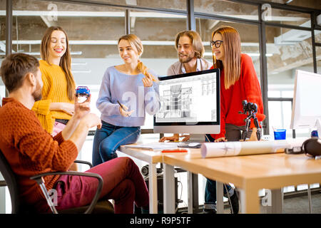 Un groupe de jeunes collaborateurs qui travaillent ensemble sur des projets architecturaux avec des ordinateurs dans les bureaux modernes Banque D'Images