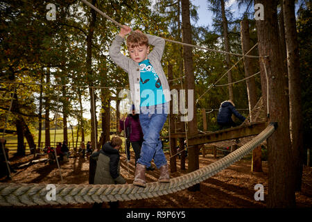 William Waugh jouant sur une corde à pied dans l'aire de jeux au parc Stockeld à Wetherby North Yorkshire Banque D'Images