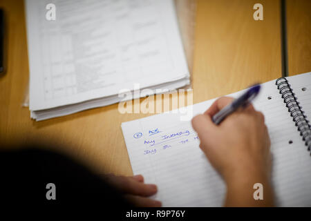 La rédaction de notes dans un carnet scolaire papier ligne à un bureau à domicile Banque D'Images
