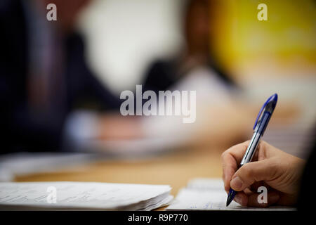 La rédaction de notes dans un carnet scolaire papier ligne à un bureau à domicile Banque D'Images
