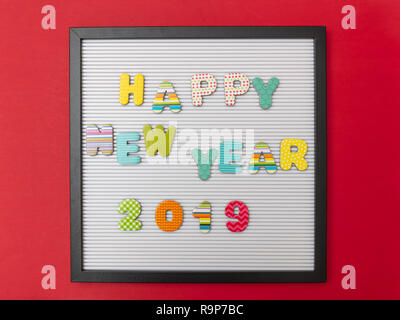 Bonne année 2019. Carte avec cadre noir, texte bonne année 2019 en lettres colorées, red wall background Banque D'Images