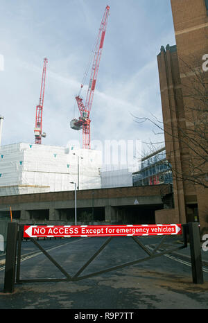 Le rouge et le blanc pas d'accès à l'exception des véhicules d'urgence signe sur un obstacle routier à Twickenham, Middlesex, Angleterre, avec des grues en arrière-plan Banque D'Images