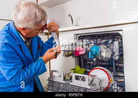 Man machine lave-vaisselle fixe uniforme bleu Banque D'Images
