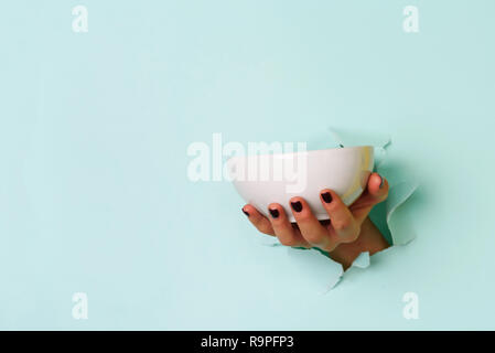 Femme hand holding bol vide sur fond bleu avec copie espace. La saine alimentation, régimes concept. Bannière. Banque D'Images