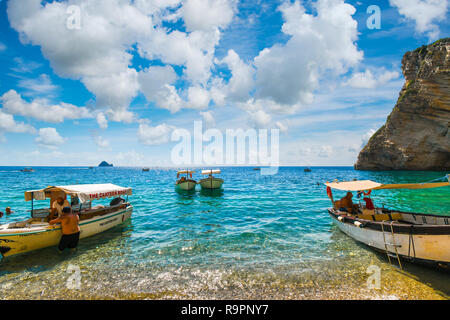 Bateaux stationnés dans et sur les rives de la plage de Paradise, ou Chomi Beach, sur l'île grecque de Corfou. Banque D'Images