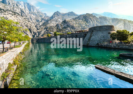 La ville médiévale et les douves séparant avec les montagnes et le château derrière dans l'Adriatique ancienne ville de Kotor, Monténégro. Banque D'Images