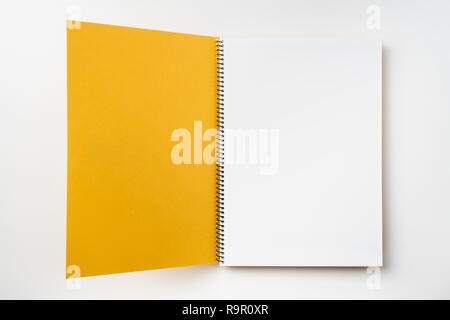Concept design - Vue de dessus le jaune carnet à spirales avec open & curl flip page laminées isolé sur maquette pour l'arrière-plan Banque D'Images