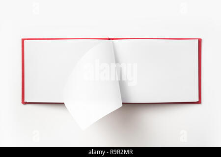 Concept design - Vue de dessus couverture cartonnée rouge portable avec open & curl flip page laminées isolé sur fond de immersive Banque D'Images