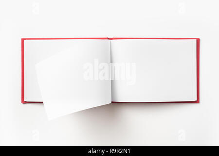 Concept design - Vue de dessus couverture cartonnée rouge portable avec open & curl flip page laminées isolé sur fond de immersive Banque D'Images