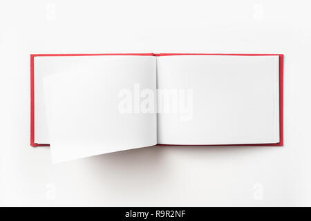 Concept design - Vue de dessus couverture cartonnée rouge portable avec open & curl flip page laminées isolé sur fond de immersive Banque D'Images